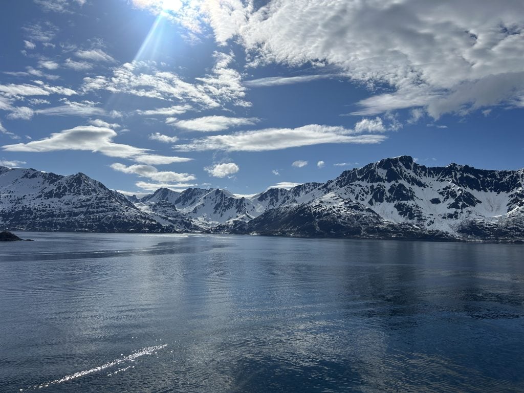 Schneebedeckte Berge an der Küste, glatte Wasseroberfläche